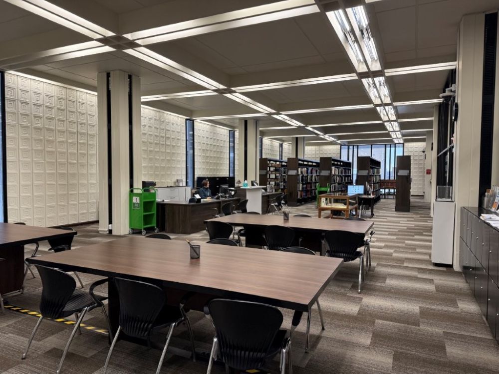 View of the Special Collections at the Davenport Public Library. It shows research tables, bookshelves, and the service desk.