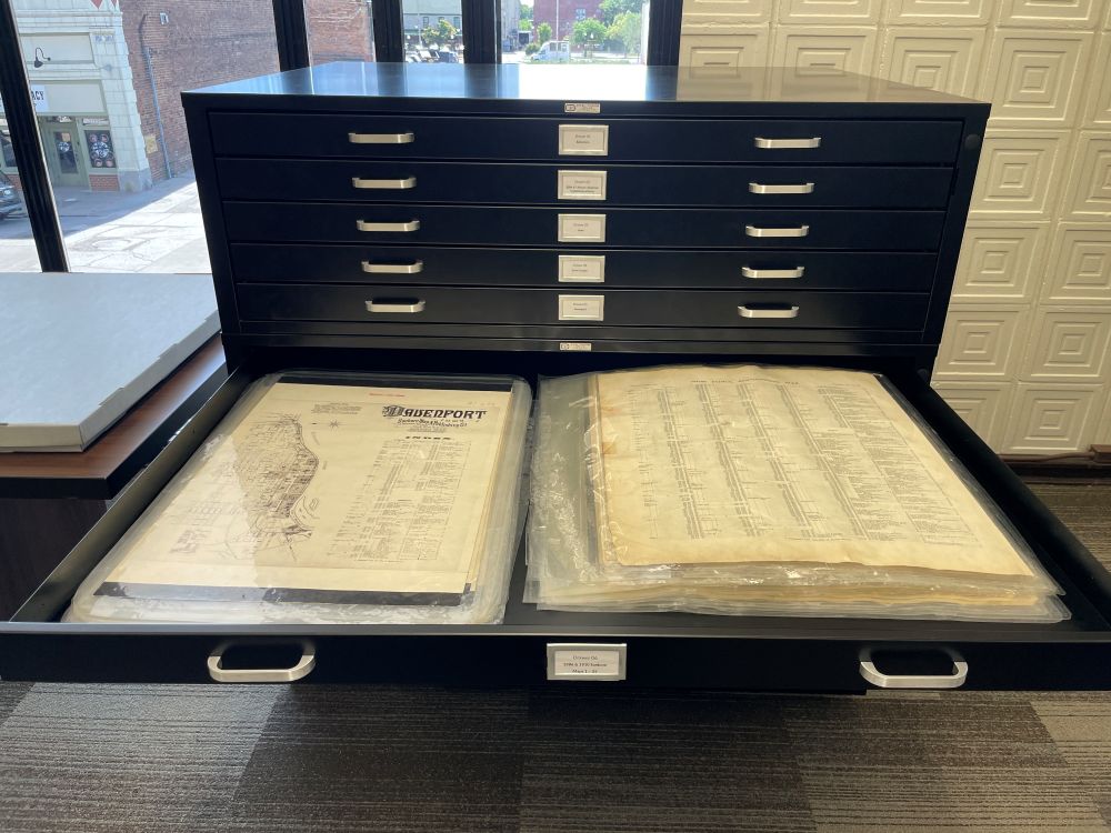 Image of a drawers pulled out showing encapsulated sheets of the1886 and 1910 Sanborn Fire Insurance maps.